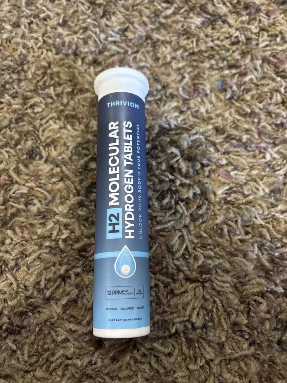 Thriviom H2 Molecular Hydrogen Tablets tube standing on a carpeted floor