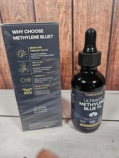 Thriviom Ultimate Methylene Blue 1% box and bottle on a rustic wooden surface