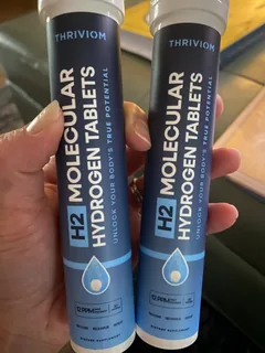 Thriviom tablet tube held next to a filled water bottle