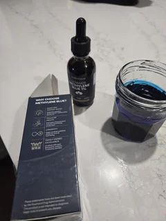 Thriviom Methylene Blue 1% bottle standing next to its packaging, showing the dropper cap and label