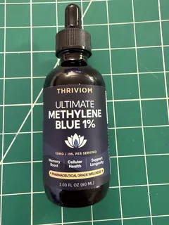 Thriviom Ultimate Methylene Blue 1% bottle standing on a wooden cutting board